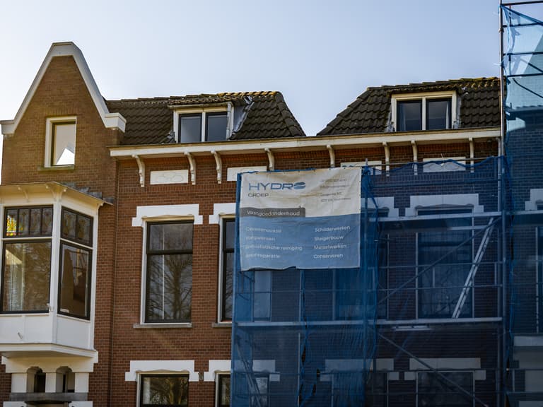Woning aan Hofsingel met steiger, blauw gaas en Hydro Groep bus bij conserveren metselwerk Vlaardingen