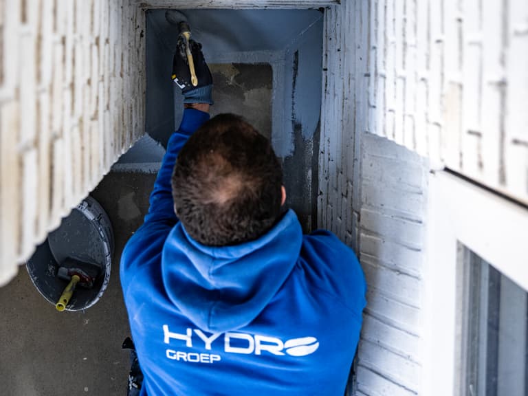 Specie op troffel tijdens voegwerkreparatie aan balkon in Rotterdam door Hydro Groep voor Verhoeven Bouwt