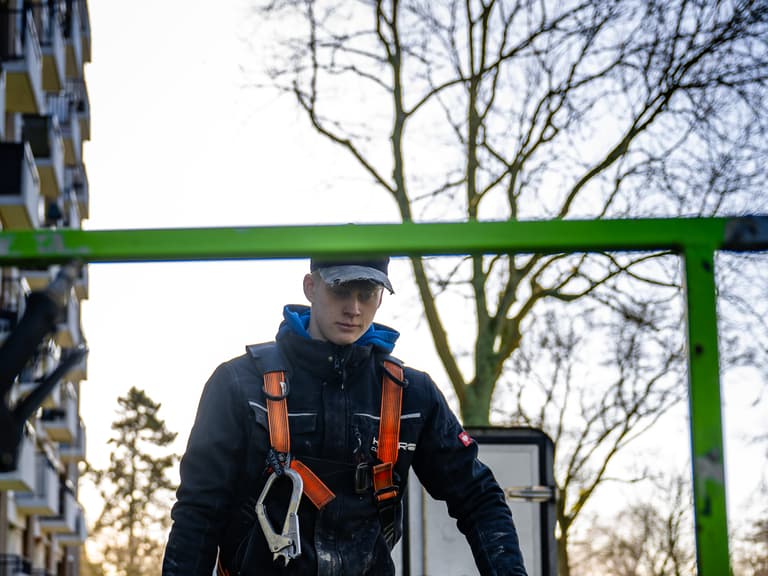 Hoogwerker bij hoge zijgevel voor reiniging in Rotterdam tijdens conserveren metselwerk door Hydro Groep