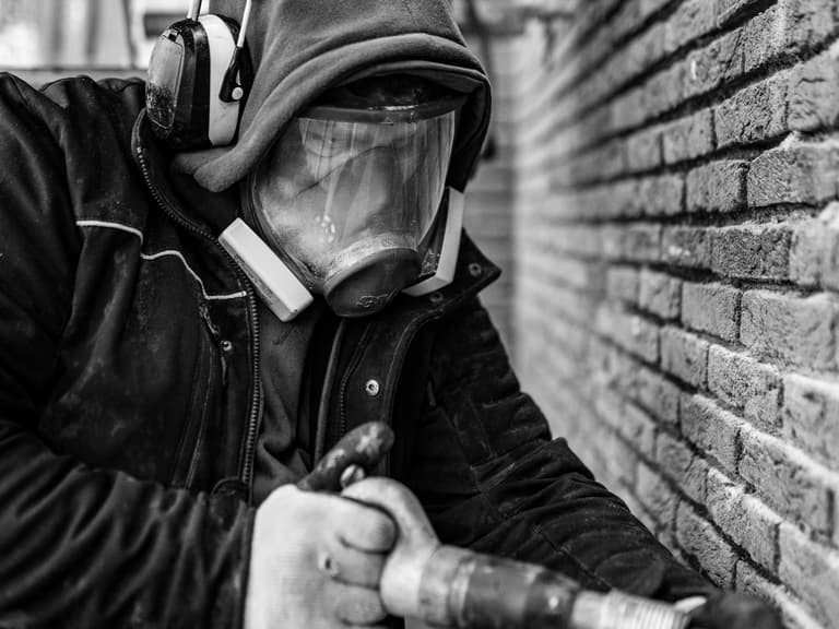 Volledig ingestelde steiger rond woning met beschermdoek in Bergschenhoek tijdens conserveren metselwerk