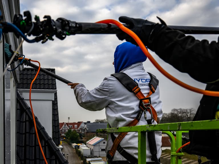 Specie op troffel voor voegwerk bij wooncomplex in Oostvoorne door Hydro Groep voor Woonbedrijf Voorne aan Zee