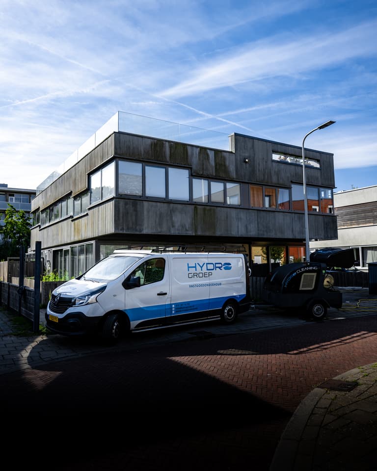 Hydro Groep bus bij woning met betonvezel gevelbeplating voor VvE Biancaland in Den Haag